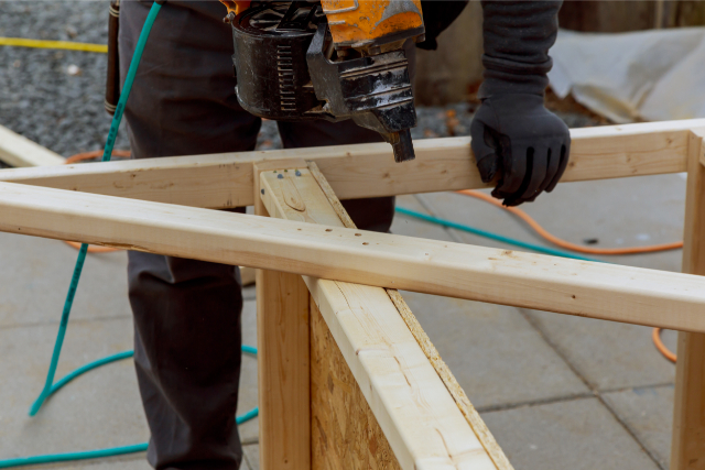 Deck Repair by worker with power tool and gloves on.