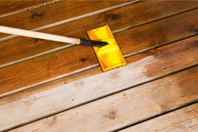Pad Brush Applying Stain to Wood Deck Boards